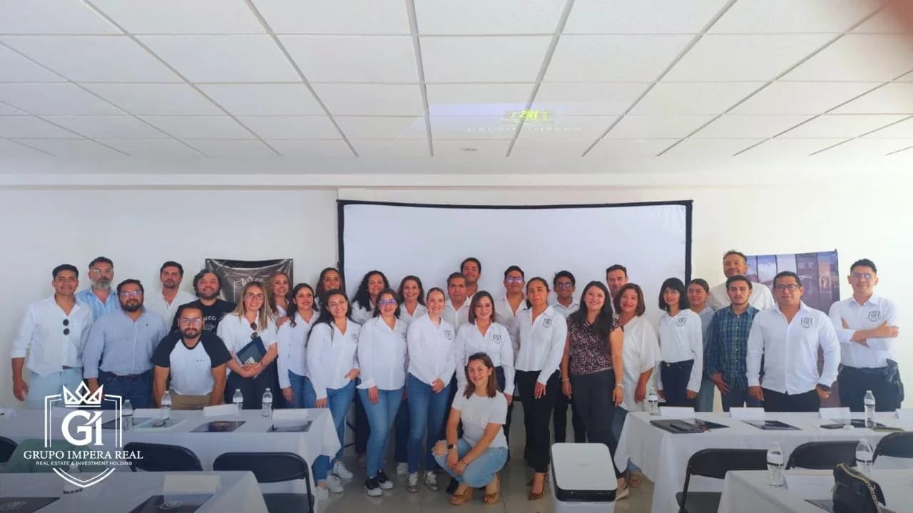 Panorámica de equipo y socios comerciales reunidos en un evento inmobiliario